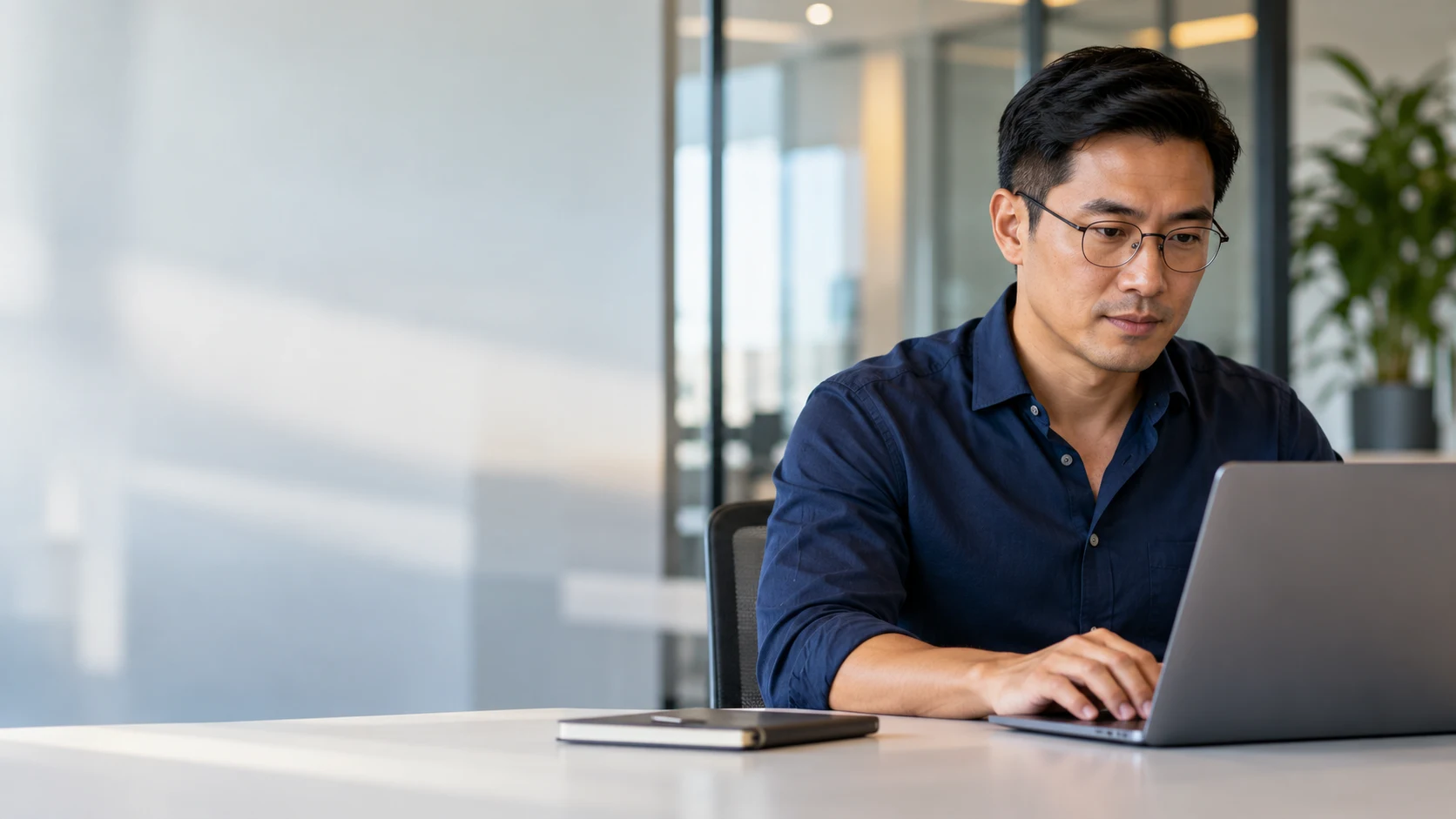 Analista financeiro consultando informações em um notebook no escritório.